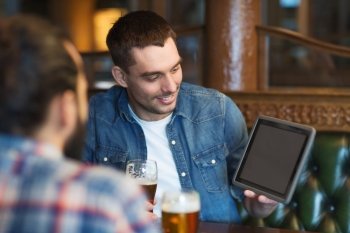 people, men, leisure, friendship and technology concept - happy male friends with tablet pc computer drinking beer at bar or pub