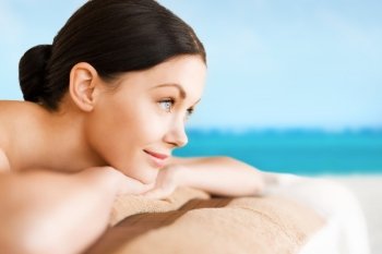 picture of woman lying on the massage desk over sea background. woman in spa
