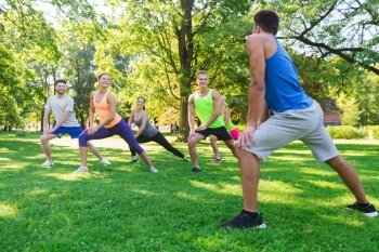 fitness, sport, friendship and healthy lifestyle concept - group of happy teenage friends or sportsmen exercising and doing lunge at boot camp
