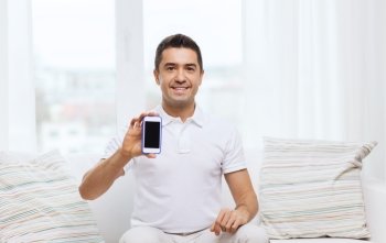 technology, people, lifestyle and communication concept - happy man showing smartphone black blank screen at home