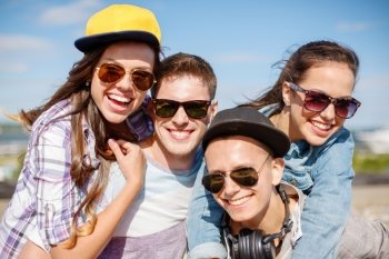 summer holidays and teenage concept - group of smiling teenagers hanging outside. group of smiling teenagers hanging out