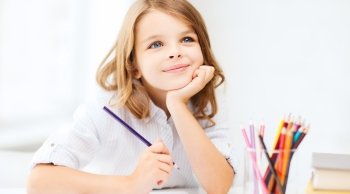 education and school concept - little student girl drawing with pencils at school. girl drawing with pencils at school