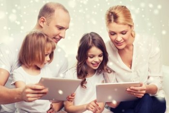 family, home, technology and people - smiling mother, father and little girls with tablet pc computers over snowflakes background