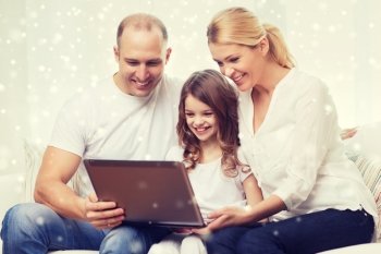family, childhood, technology and people concept - smiling family with laptop computer over snowflakes background