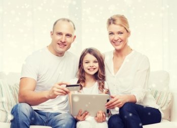 family, holidays, shopping, technology and people concept - happy family with tablet pc computer and credit card over snowflakes background