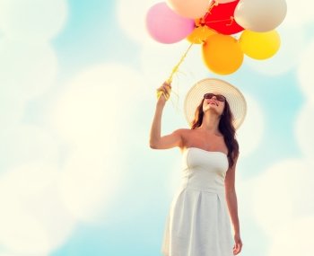 happiness, summer, holidays and people concept - smiling young woman wearing sunglasses with balloons over blue lights background