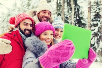 technology, season, friendship and people concept - group of smiling men and women taking selfie tablet pc computer in winter forest