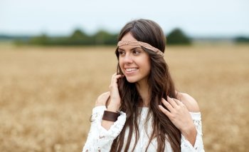 nature, summer, youth culture and people concept - smiling young hippie woman on cereal field