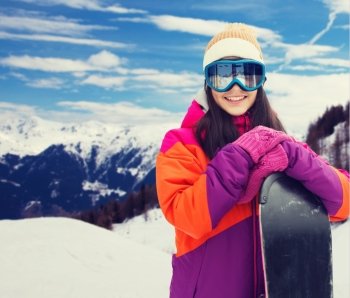 winter, leisure, sport and people concept - happy young woman in ski goggles with snowboard over snow and mountain background