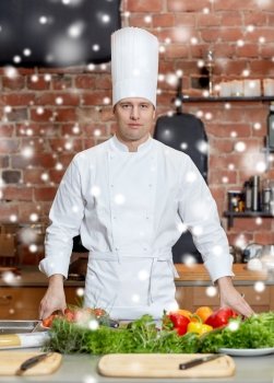 cooking, food and people concept - happy male chef cook with vegetables on restaurant kitchen table over snow effect