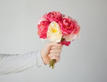 close up of man's hand giving bouquet of flowers.