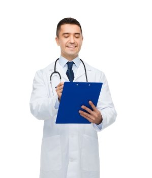 medicine, profession and healthcare concept - smiling male doctor with clipboard and stethoscope writing prescription