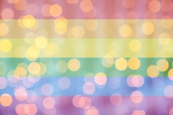 holidays, gay pride, homosexuality and tolerance concept - blurred golden lights over rainbow flag background