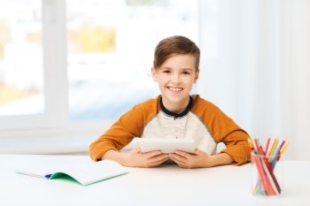 leisure, children, education, technology and people concept - smiling boy with tablet pc computer and notebook at home