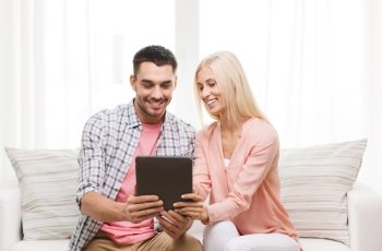 love, family, technology, internet and happiness concept - smiling happy couple with tablet pc computer at home
