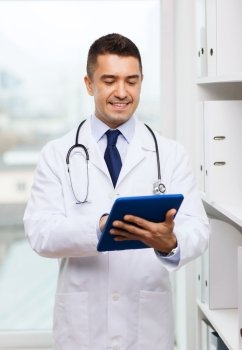 healthcare, technology, profession, people and medicine concept - smiling male doctor in white coat with tablet pc computer in medical office