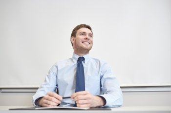 business, people and work concept - smiling businessman sitting in office in front of whiteboard