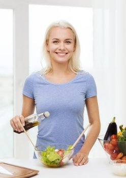 healthy eating, vegetarian food, cooking, dieting and people concept - smiling young woman dressing vegetable salad at home