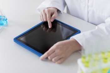 science, chemistry, biology, medicine and people concept - close up of young female scientist with tablet pc computer making test or research in clinical laboratory
