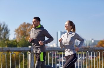 fitness, sport, people and lifestyle concept - happy couple running outdoors