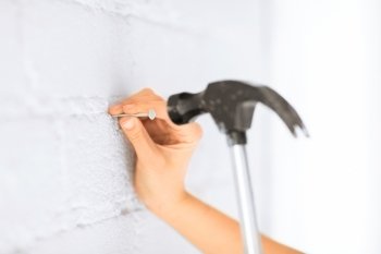 architecture and home renovation concept - architect hammering nail in wall. architect hammering nail in wall