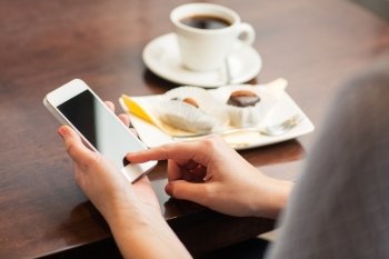 business, people, technology and lifestyle concept - close up of woman with smartphone, coffee and dessert