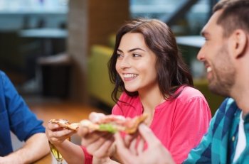 leisure, food and drinks, people and holidays concept - smiling friends eating pizza and drinking beer at restaurant or pub