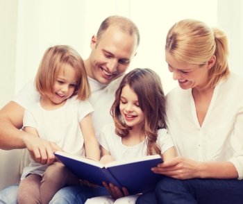 family, child and home concept - smiling family and two little girls with book at home