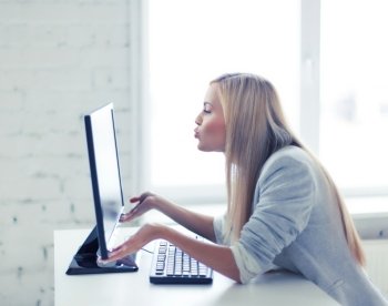 picture of happy woman kissing computer monitor. happy woman with laptop computer