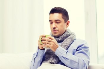 healthcare, people and medicine concept - ill man with flu drinking hot tea from cup at home