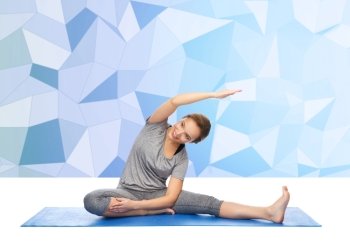 fitness, sport, people and healthy lifestyle concept - happy woman making yoga and stretching on mat over low poly background