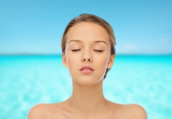 beauty, people and health concept - young woman face with closed eyes and shoulders over blue sea and sky background