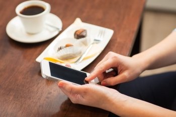business, people, technology and lifestyle concept - close up of woman with smartphone, coffee and dessert