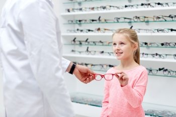 health care, people, eyesight and vision concept - optician giving glasses to little girl at optics store