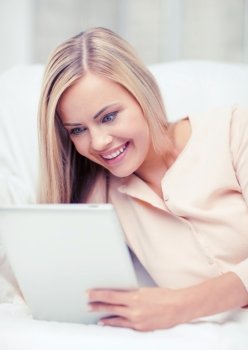 leisure and education concept - smiling woman lying on the couch with tablet pc. woman with tablet pc