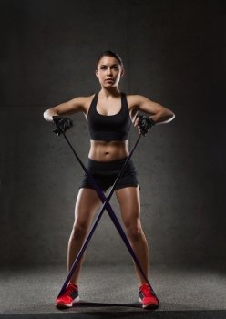 fitness, sport, training, people and lifestyle concept - woman doing exercises with expander or resistance band in gym