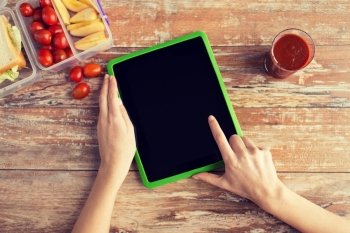 healthy eating, dieting, technology and people concept - close up of woman hands with blank tablet pc computer and food in plastic container on table at home