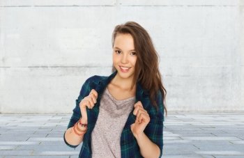 people and teens concept - happy smiling pretty teenage girl over gray urban street background. happy smiling pretty teenage girl