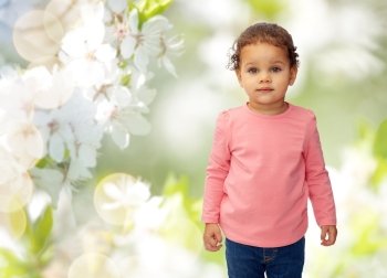 childhood, fashion, clothing and people concept - beautiful little african american baby girl portrait over cherry blossoms background