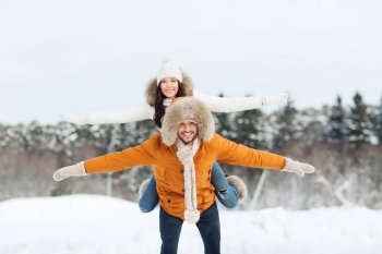 people, season, love and leisure concept - happy couple having fun over winter background