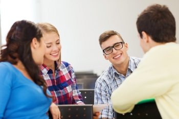 education, high school, teamwork and people concept - group of smiling students sitting and talking in lecture hall