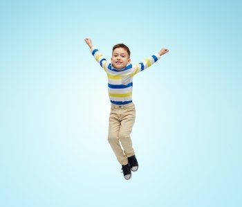 happiness, childhood, freedom, movement and people concept - happy little boy jumping in air over blue background