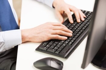 business, people and technology concept - close up of businessman hands typing on computer keyboard at office