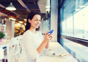 drinks, food, people, technology and lifestyle concept - smiling young woman with smartphone drinking coffee at cafe