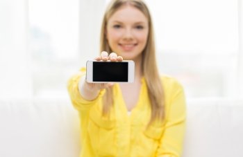 people, technology and advertisement concept - close up of young woman showing smartphone blank screen at home
