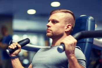 sport, fitness, bodybuilding, lifestyle and people concept - man exercising and flexing muscles on gym machine