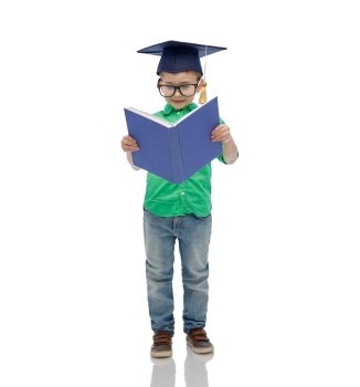 childhood, school, education, knowledge and people concept - happy boy in bachelor hat or mortarboard and eyeglasses