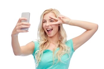 emotions, expressions and people concept - happy smiling young woman or teenage girl taking selfie with smartphone