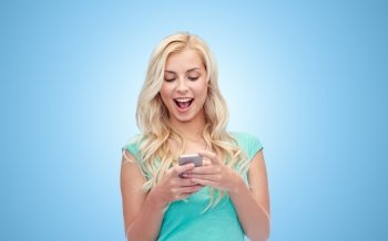 emotions, expressions, technology and people concept - smiling young woman or teenage girl texting on smartphone over blue background