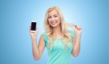 emotions, expressions, technology and people concept - smiling young woman or teenage girl showing blank smartphone screen over blue background